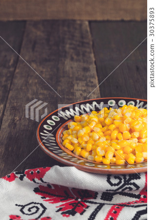 Canned corn in a brown bowl on wooden 30375893