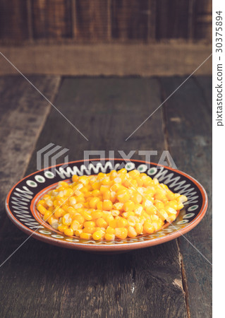 Canned corn in a brown bowl on wooden 30375894