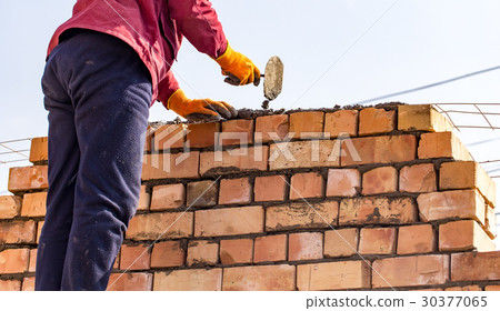 Worker builds a brick wall in the house Worker builds a brick wall in the house 30377065