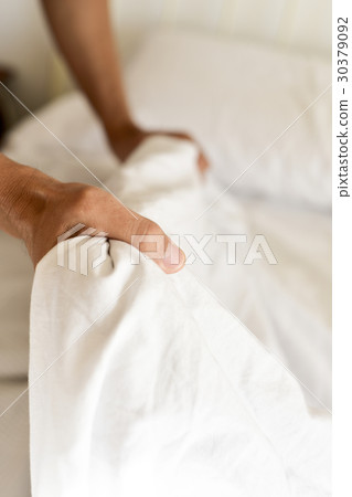 young man making the bed 30379092