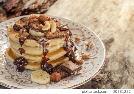 Stack of hot pancakes with nuts, bananas Stack of hot pancakes with nuts, bananas 30381252