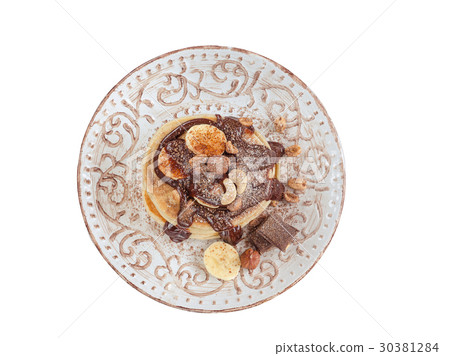 Stack of hot pancakes with nuts, bananas. Isolated 30381284