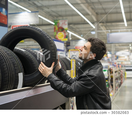 male customer choosing new tires 30382083