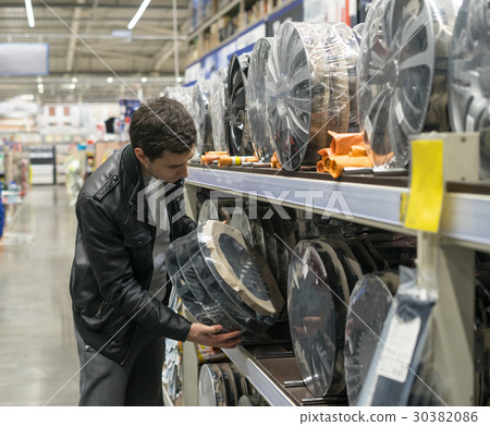 male customer choosing new wheel covers male customer choosing new wheel covers 30382086