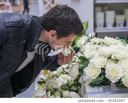 Handsome man choosing roses at a florist shop for Handsome man choosing roses at a florist shop for 30382087