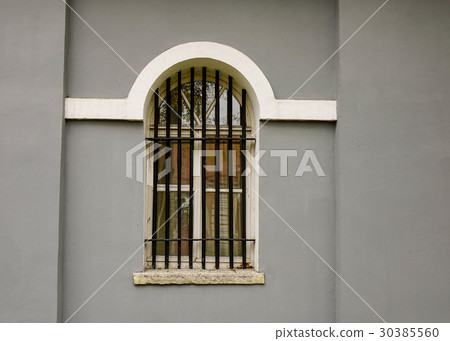 Window on the gray brick wall of old building 30385560