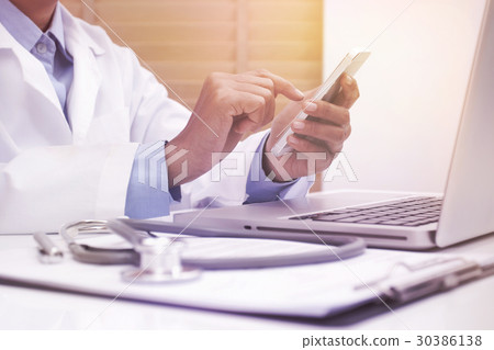 Woman doctor using mobile smart phone. Woman doctor using mobile smart phone. 30386138