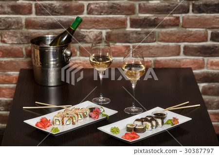 Two sets of sushi rolls with chopsticks and wine 30387797