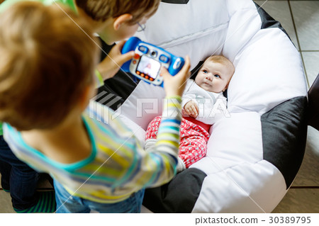 Two siblings kids boys taking picture with toy Two siblings kids boys taking picture with toy 30389795