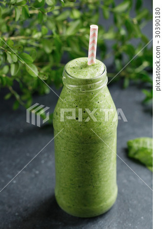 Glass bottle with green spinach detox smoothies on 30390180