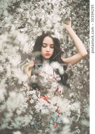 Beautiful young lady in the garden of cherry blossoms 30394295