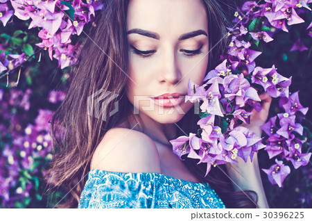 Beautiful young woman surrounded by flowers 30396225