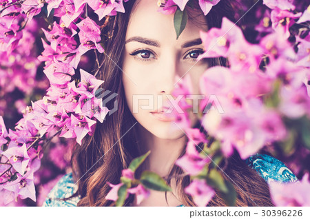 Beautiful young woman surrounded by flowers 30396226