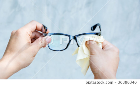 Man cleaning the glasses with microfiber fabric. Man cleaning the glasses with microfiber fabric. 30396340