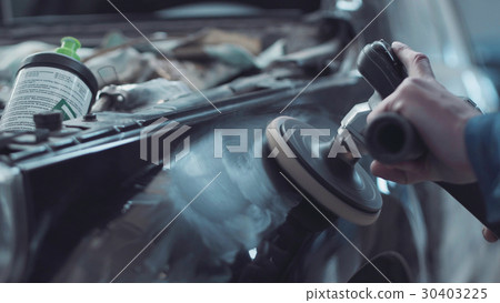 Mechanic using a rotary polisher on a car 30403225