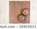 two wooden bowls over empty go game board 30403623
