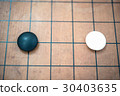 white stone approach to black stone on go game board 30403635