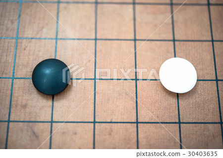 white stone approach to black stone on go game board 30403635