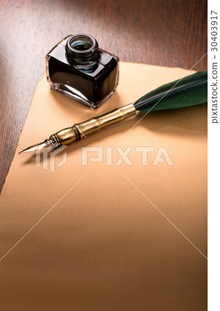 Quill pen and paper on wooden table 30403917