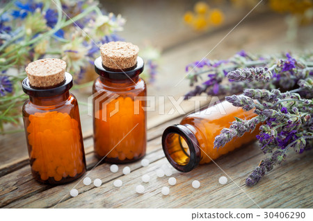 Bottles of homeopathic globules and healing herbs Bottles of homeopathic globules and healing herbs 30406290