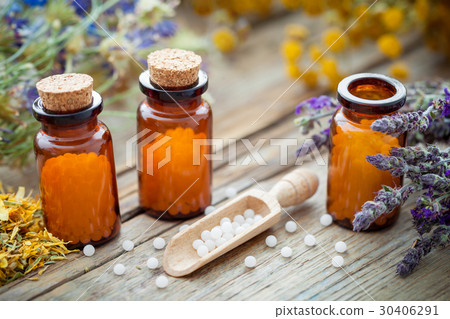 Bottles of homeopathic globules and healing herbs. Bottles of homeopathic globules and healing herbs. 30406291