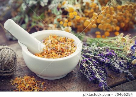Mortar of dried marigold flowers and healing herbs 30406294