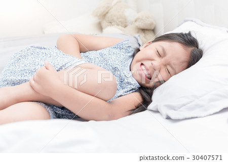 asian girl feeling stomachache pain on bed, 30407571