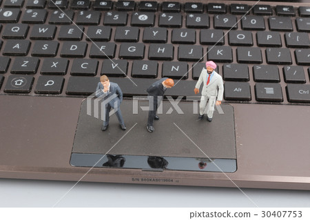 Mini workmen repairing a laptop key board. 30407753