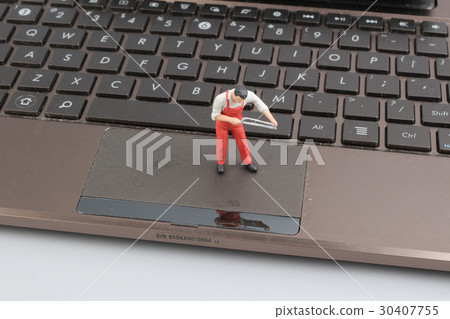 Mini workmen repairing a laptop key board. Mini workmen repairing a laptop key board. 30407755
