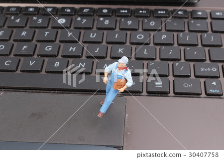 Mini workmen repairing a laptop key board. Mini workmen repairing a laptop key board. 30407758