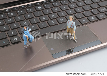 Mini workmen repairing a laptop key board. Mini workmen repairing a laptop key board. 30407771