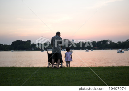 Grandfather with granddaughter look at the lake  30407974