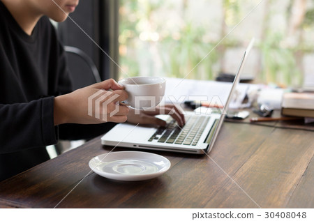 Student hand holding a coffee and using laptop 30408048