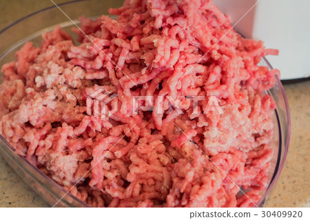 Close-up of minced meat coming out from grinder Close-up of minced meat coming out from grinder 30409920