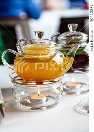 Tea from sea buckthorn in a glass teapot  30410872