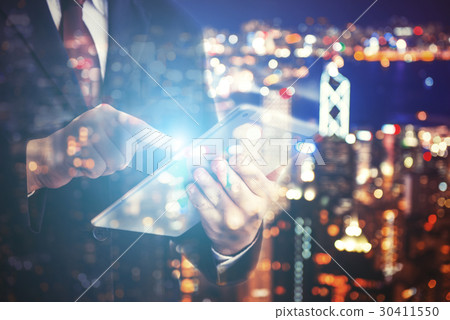 Business man pointing tablet on blurry background. 30411550