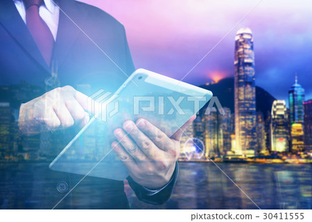 Business man holding tablet on blurry background. 30411555