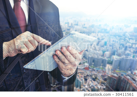 Business man holding tablet on blurry background. 30411561