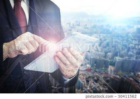 Business man holding tablet on blurry background. 30411562