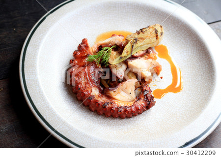 Grilled octopus tentacles on dish. Grilled octopus tentacles on dish. 30412209