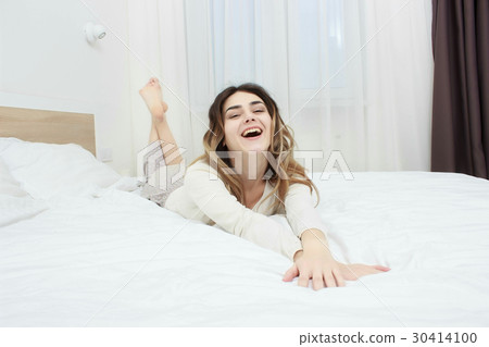 Beautiful girl lying in bedroom at early morning 30414100