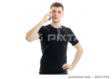 a young guy in a black t-shirt is calling on a 30415343