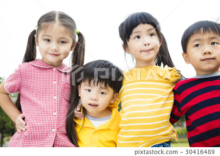 Group of smiling kids standing outside together Group of smiling kids standing outside together 30416489