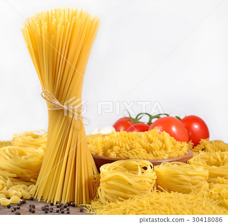 Uncooked Italian pasta, ripe tomatoes branch Uncooked Italian pasta, ripe tomatoes branch 30418086