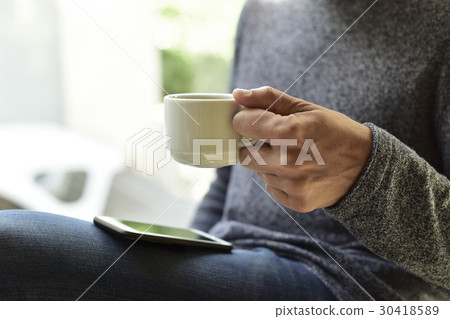 young man with a coffee using a smartphone young man with a coffee using a smartphone 30418589