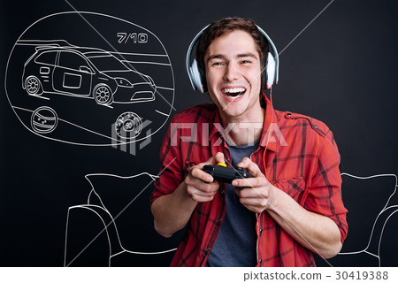Overjoyed smiling young man playing video games Overjoyed smiling young man playing video games 30419388
