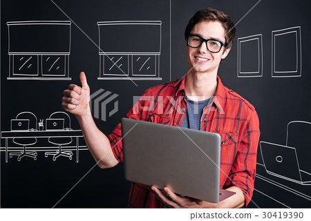 Positive student holding laptop 30419390