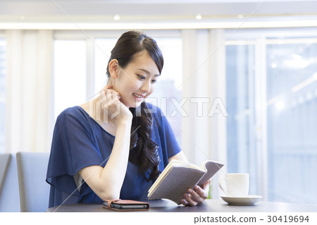 A woman reading at a cafe A woman reading at a cafe 30419694
