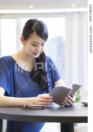A woman reading at a cafe 30419695