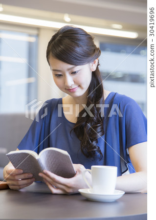 A woman reading at a cafe A woman reading at a cafe 30419696